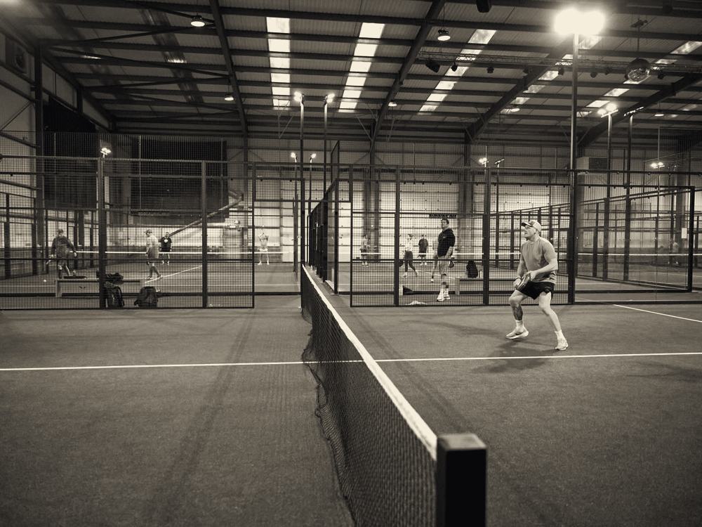 Indoor padel court with glass walls and LED lighting